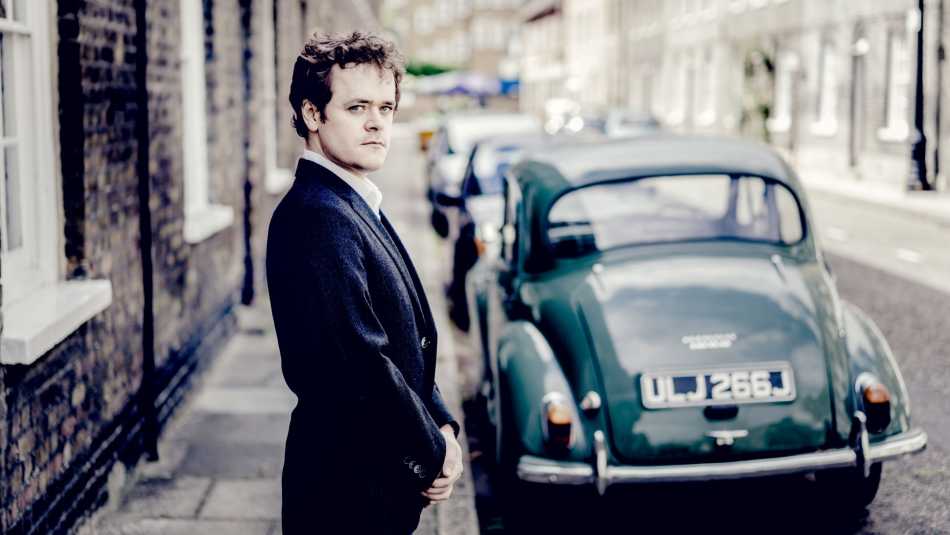 Benjamin Grosvenor an einer Straße in London, im Hintergrund ein VW Käfer