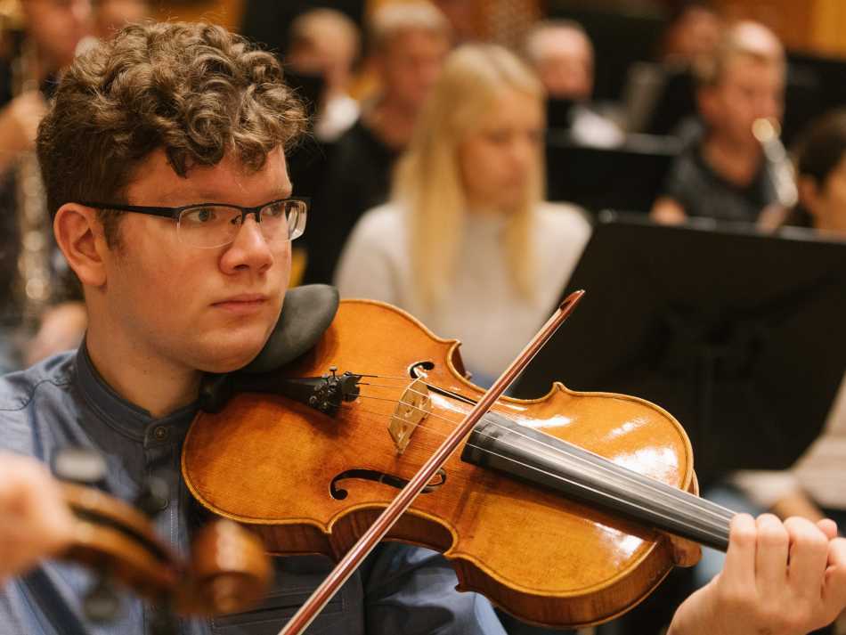 Samuel Mittag mitten im Orchester spielt Viola