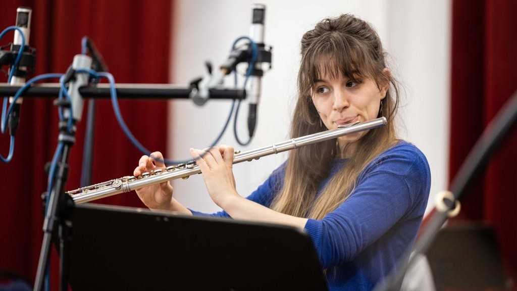 Joséphine Olech spielt Flöte, vor ihr ein Notenständer und Aufnahmemikros